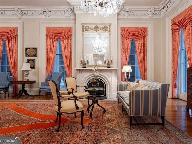 living area featuring an inviting chandelier, wood-type flooring, and ornamental molding