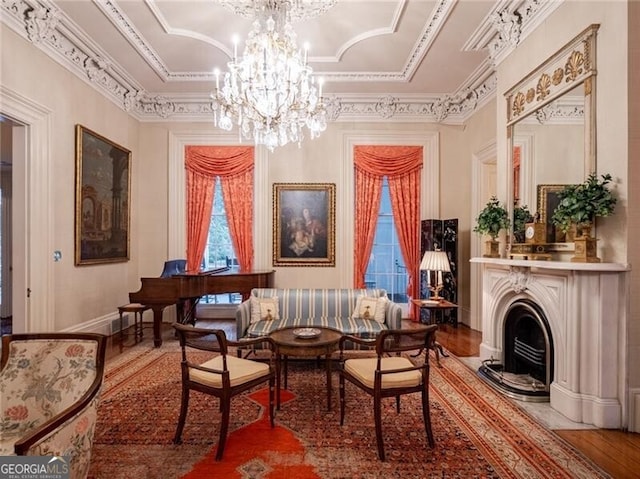 sitting room with crown molding, a chandelier, and hardwood / wood-style floors