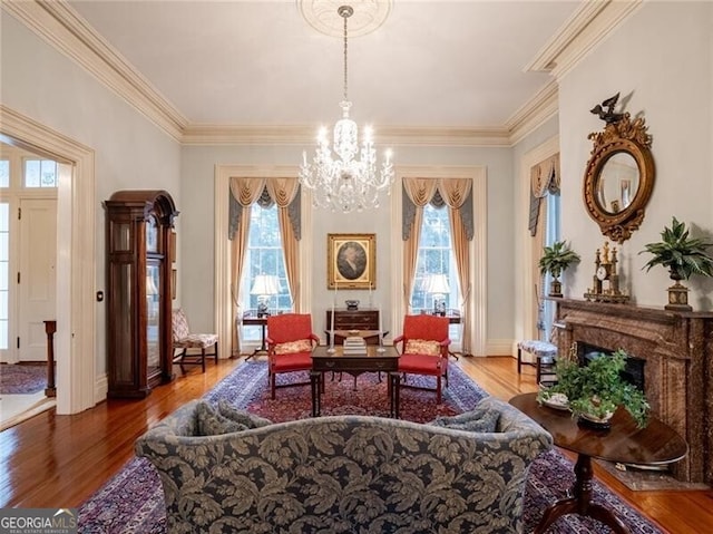 sitting room with an inviting chandelier, hardwood / wood-style flooring, and ornamental molding