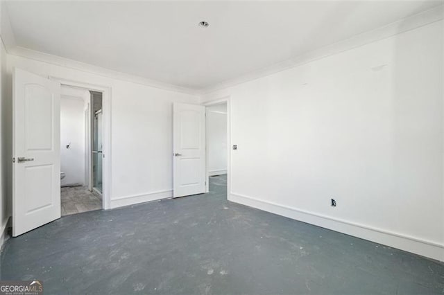 unfurnished bedroom featuring ornamental molding and ensuite bathroom