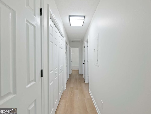 corridor with light hardwood / wood-style flooring