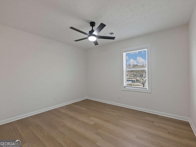 empty room featuring ceiling fan, a textured ceiling, and light hardwood / wood-style flooring