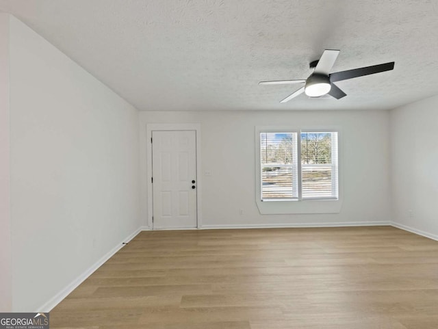 spare room featuring ceiling fan, a textured ceiling, and light wood-type flooring