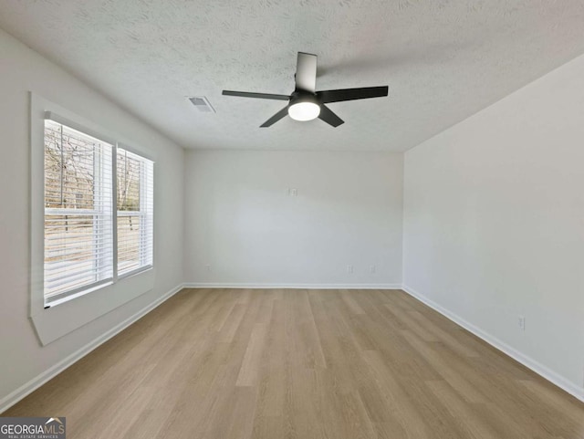 spare room with ceiling fan, light hardwood / wood-style flooring, and a textured ceiling