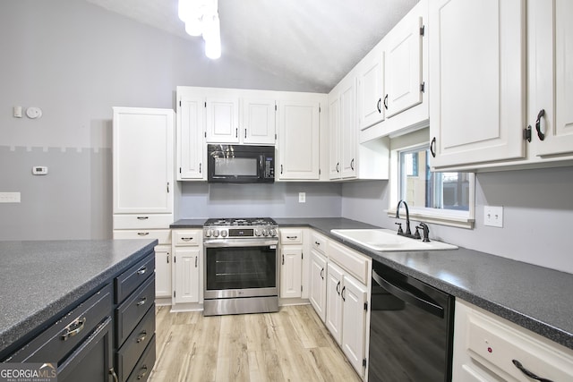 kitchen featuring white cabinetry, lofted ceiling, sink, and black appliances