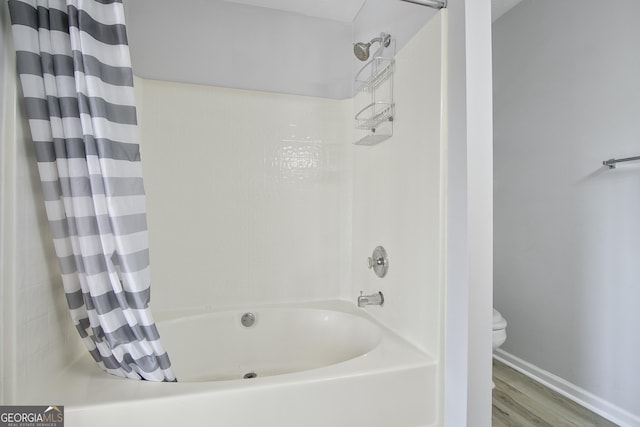 bathroom featuring shower / tub combo with curtain, hardwood / wood-style floors, and toilet