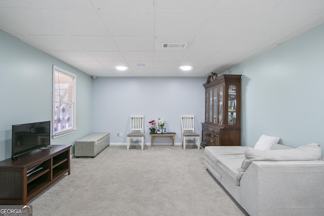 sitting room featuring a paneled ceiling and light carpet