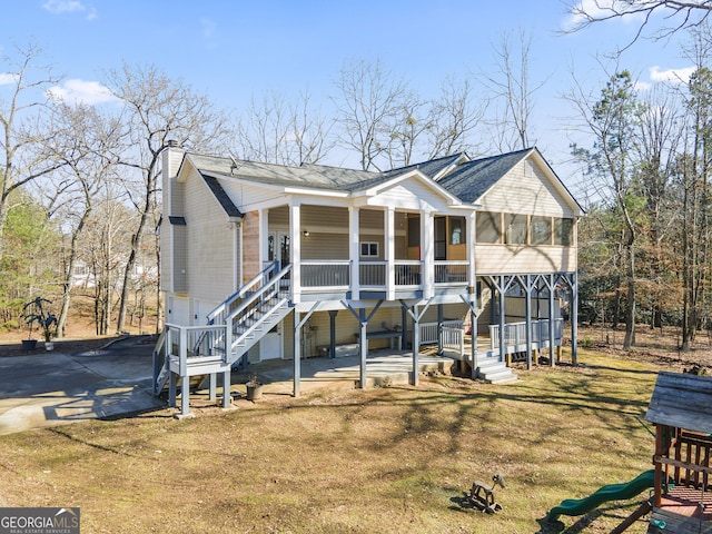 view of front facade featuring a patio, a playground, a sunroom, and a front yard