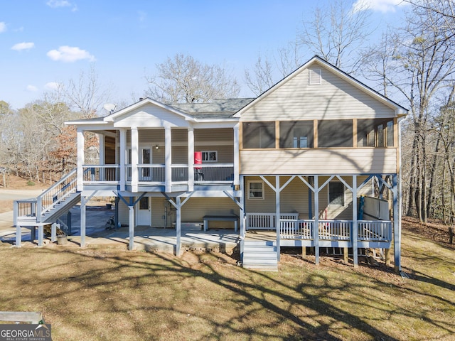 view of front of house featuring a front yard, a patio area, and a sunroom