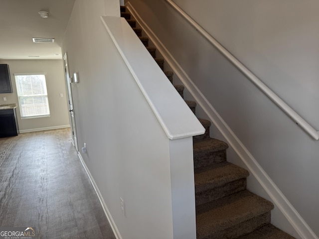 staircase with hardwood / wood-style floors