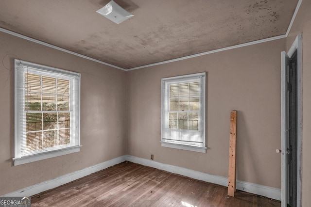 empty room with crown molding and hardwood / wood-style floors