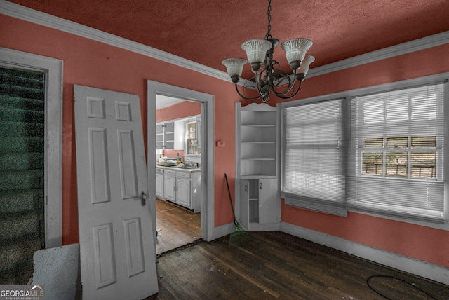 unfurnished dining area featuring sink, crown molding, a textured ceiling, dark hardwood / wood-style floors, and a notable chandelier