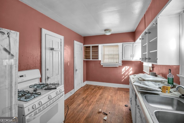 kitchen featuring white cabinetry, white gas range, sink, and dark wood-type flooring