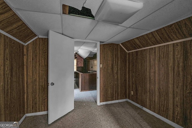 additional living space featuring carpet floors, wooden walls, and vaulted ceiling