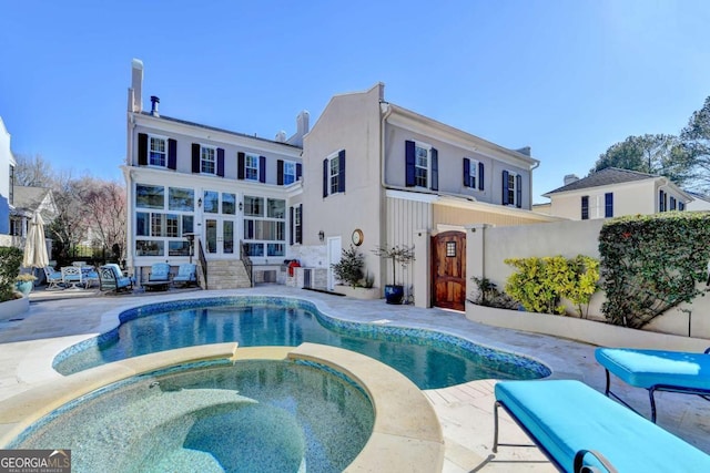 view of swimming pool featuring an in ground hot tub and a patio