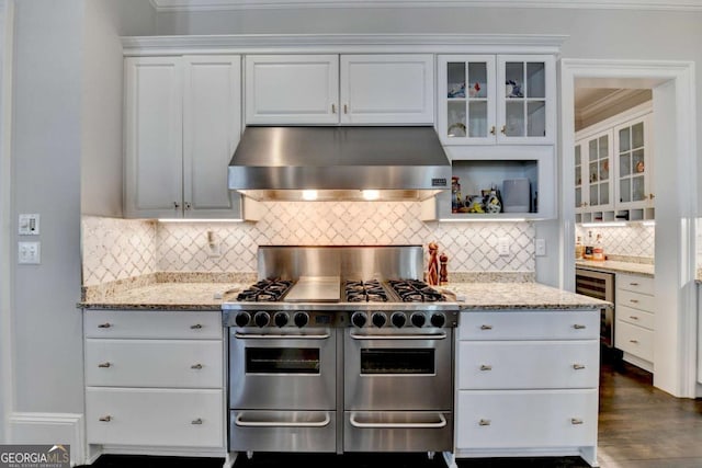 kitchen with white cabinetry, double oven range, extractor fan, and light stone counters