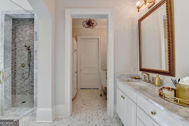 bathroom featuring vanity, ornamental molding, and tiled shower