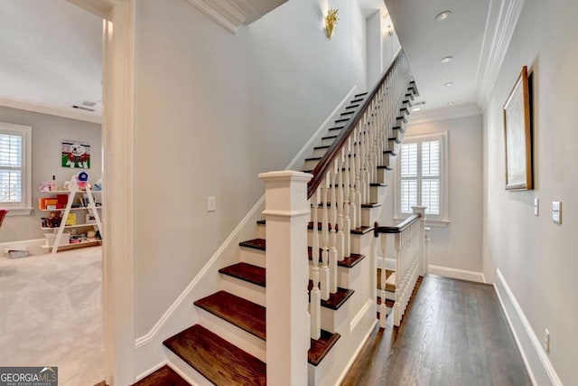 stairs featuring hardwood / wood-style flooring, ornamental molding, and a wealth of natural light