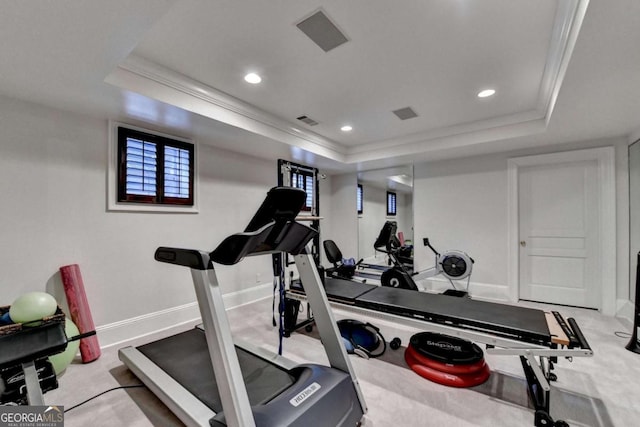 exercise area with crown molding and a tray ceiling