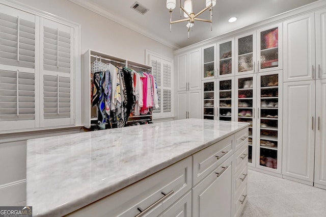 spacious closet with a chandelier