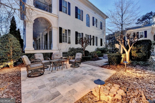 exterior space with a fire pit and a balcony