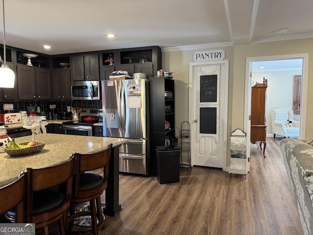 kitchen featuring decorative light fixtures, ornamental molding, dark hardwood / wood-style floors, and appliances with stainless steel finishes