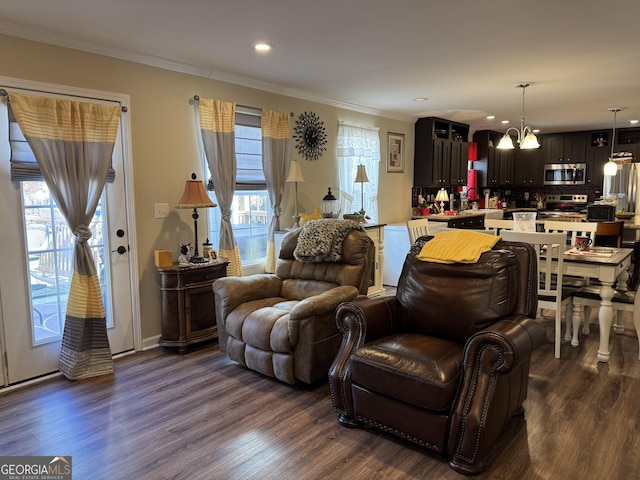 living room with crown molding, dark hardwood / wood-style floors, and an inviting chandelier