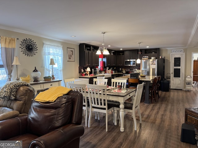 dining area featuring dark wood-type flooring, a healthy amount of sunlight, and crown molding