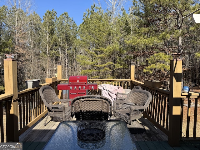 deck featuring an outdoor living space with a fire pit