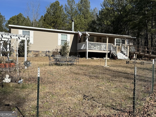 back of property with a wooden deck and a pergola