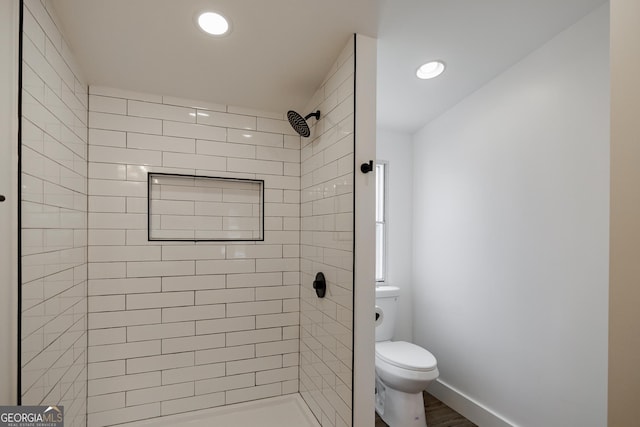 bathroom featuring toilet and a tile shower