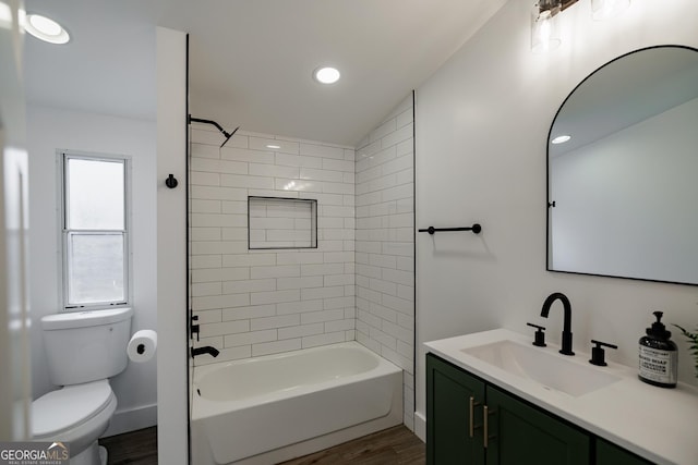 full bathroom with tiled shower / bath, vanity, toilet, and wood-type flooring