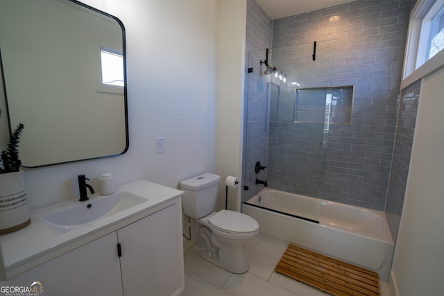 full bathroom with vanity, tiled shower / bath combo, plenty of natural light, and toilet