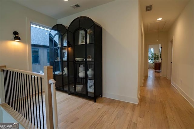 corridor featuring a healthy amount of sunlight and light hardwood / wood-style floors