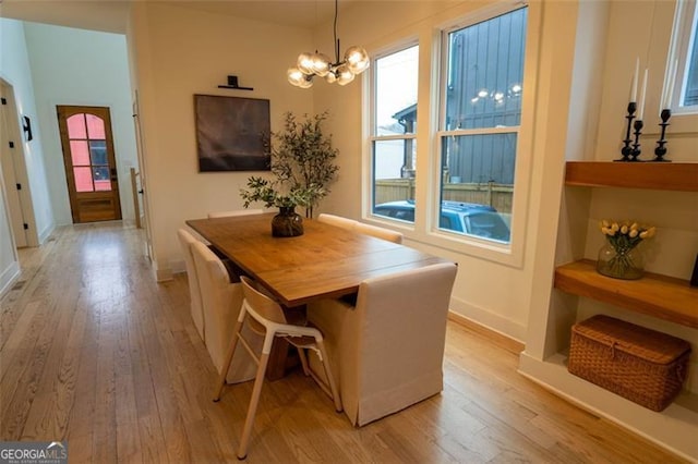 dining space featuring a notable chandelier and light wood-type flooring