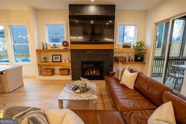 living room with light hardwood / wood-style floors and a tile fireplace