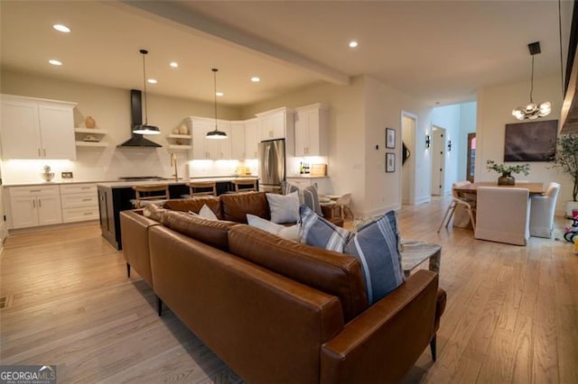 living room with sink, a chandelier, and light hardwood / wood-style floors