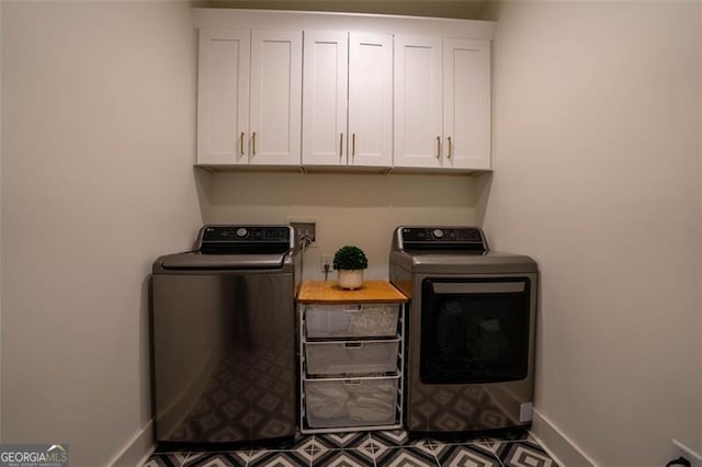 washroom featuring cabinets and washing machine and dryer