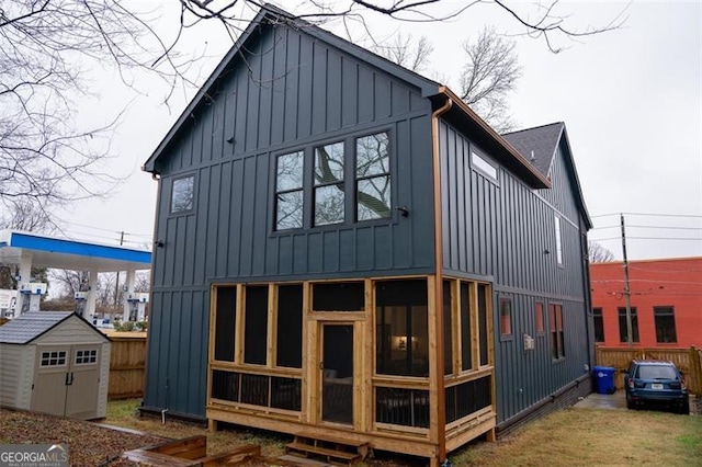 back of house with a storage shed