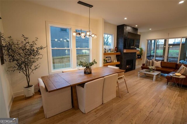 dining space with a fireplace, plenty of natural light, and light wood-type flooring