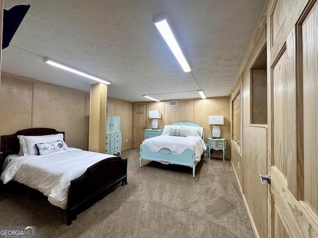 carpeted bedroom with a textured ceiling and wood walls