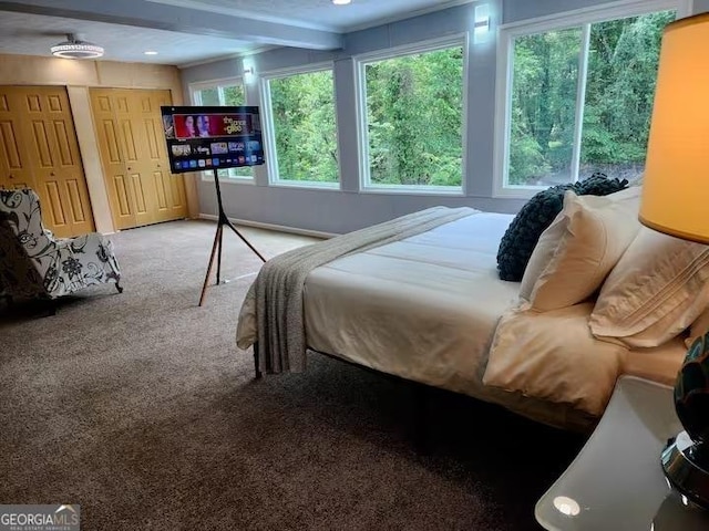 carpeted bedroom with beamed ceiling