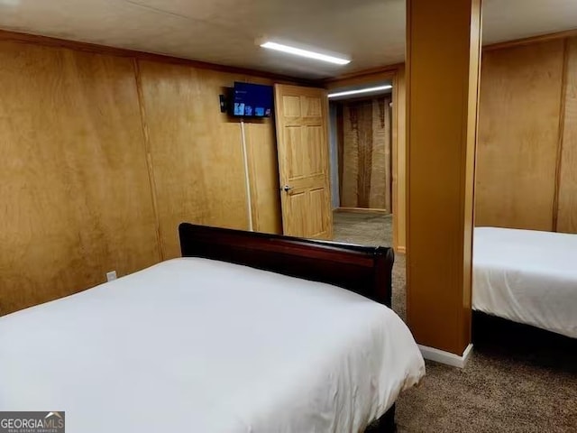 bedroom featuring wooden walls and carpet floors