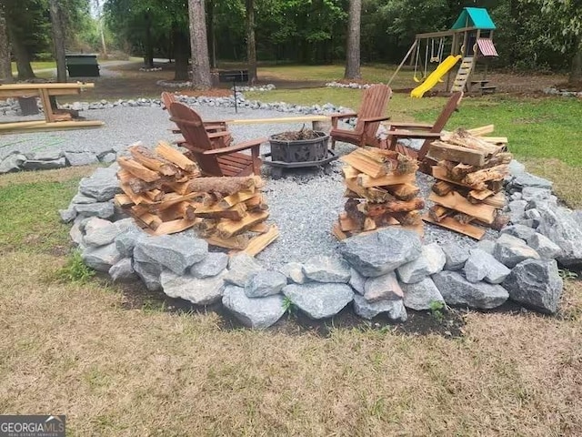 view of yard with an outdoor fire pit and a playground