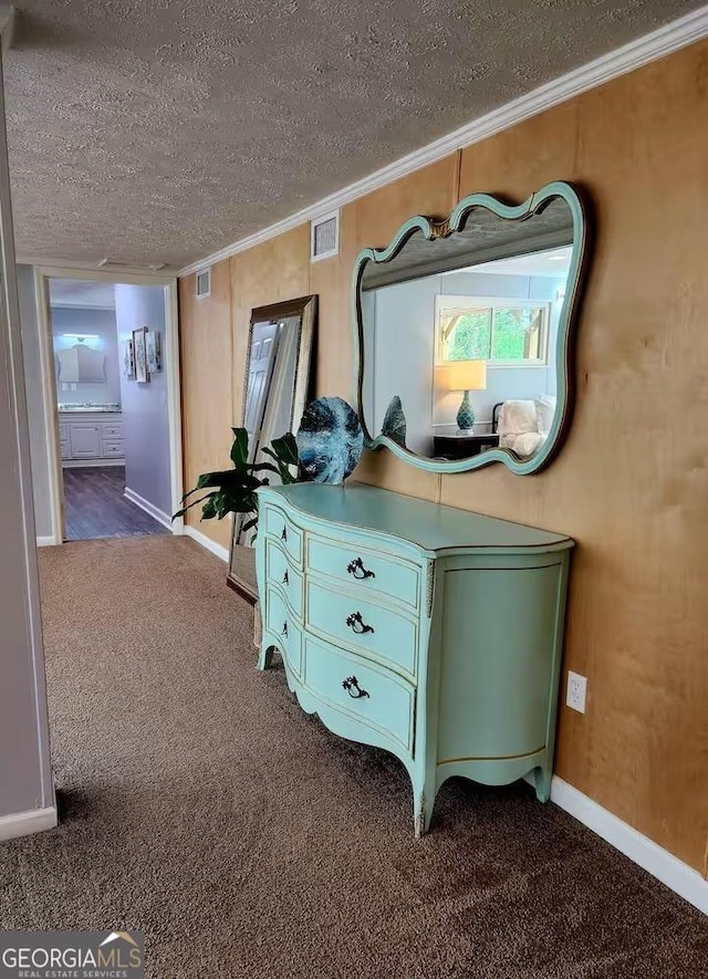 interior space featuring crown molding, carpet, and a textured ceiling