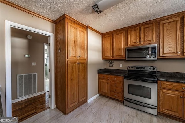 kitchen featuring stainless steel appliances and a textured ceiling