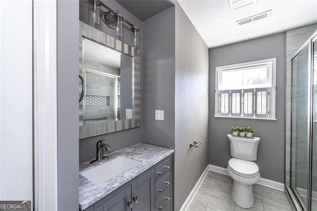 bathroom featuring vanity, a shower with door, and toilet