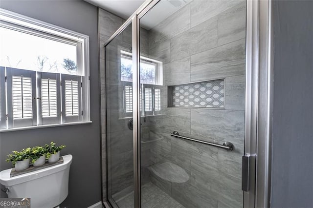 bathroom with an enclosed shower and toilet