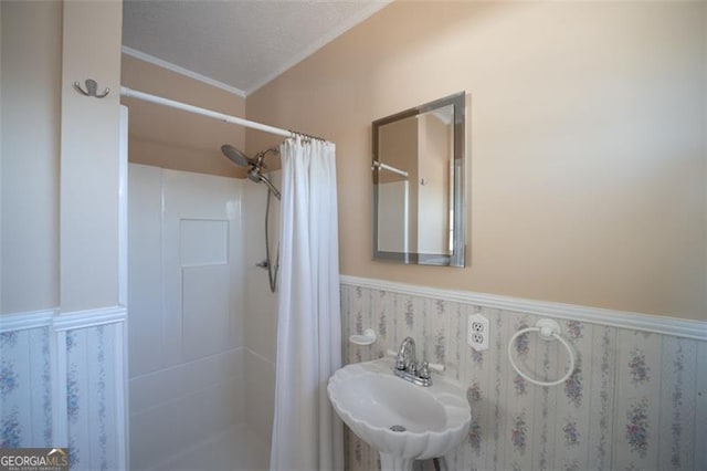 bathroom with sink, curtained shower, and a textured ceiling