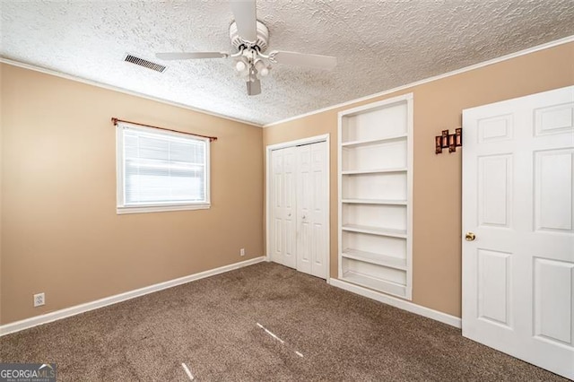 unfurnished bedroom with crown molding, a closet, carpet floors, and a textured ceiling